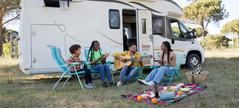 Grupa ludzi urządziła camping z gitarą i RV